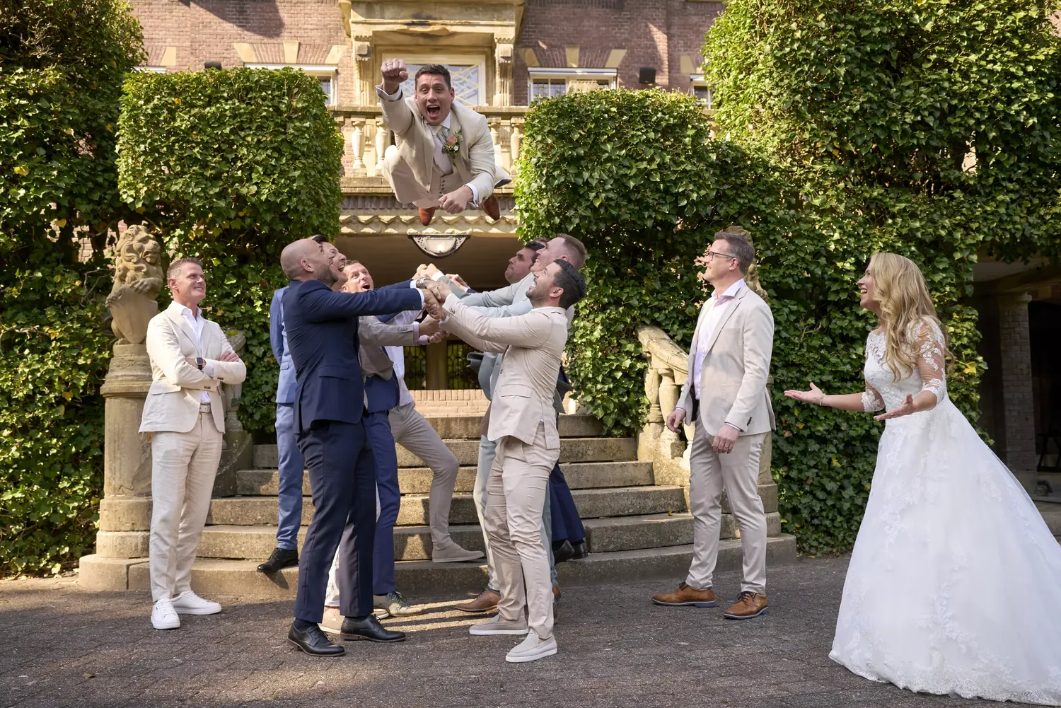 Bruidegom wordt door zijn vrienden de lucht in gegooid op Kasteel de Hooge Vuursche