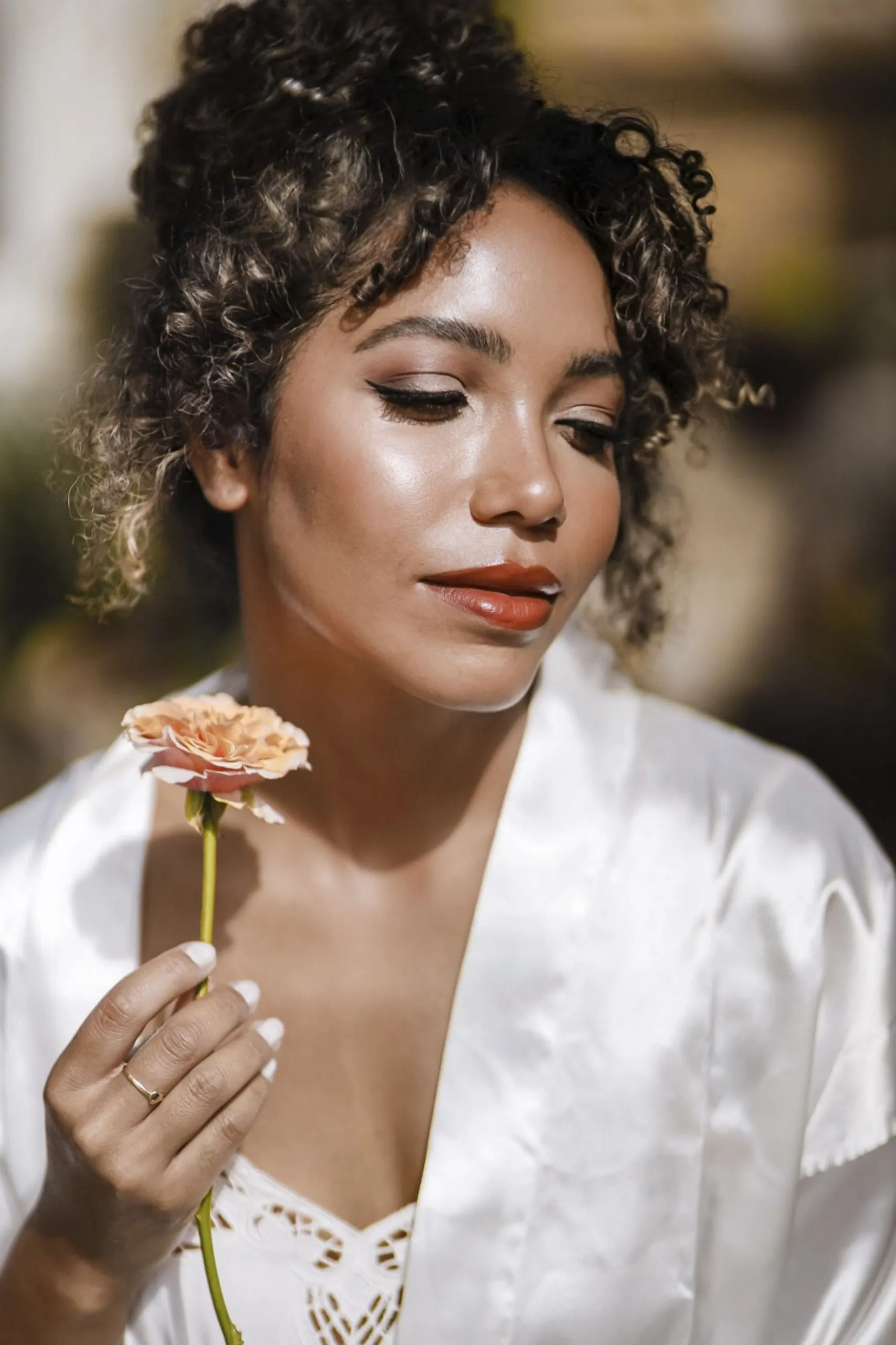 Bruid met een bloem in haar hand, portret in zacht licht