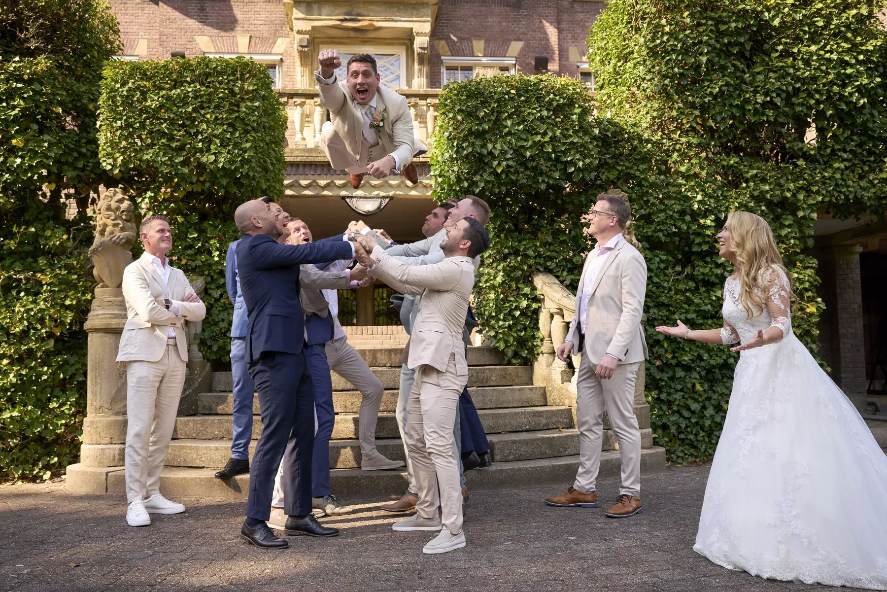 Bruidegom wordt door zijn vrienden de lucht in gegooid op Kasteel de Hooge Vuursche