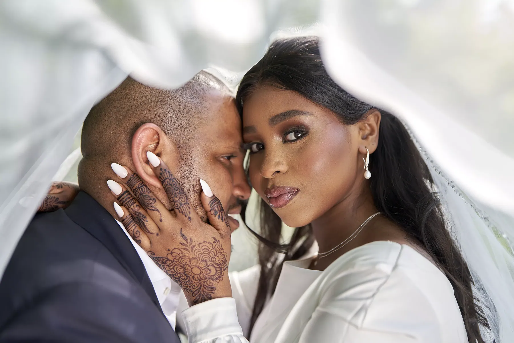 Bruidspaar samen onder de sluier tijdens de fotoshoot