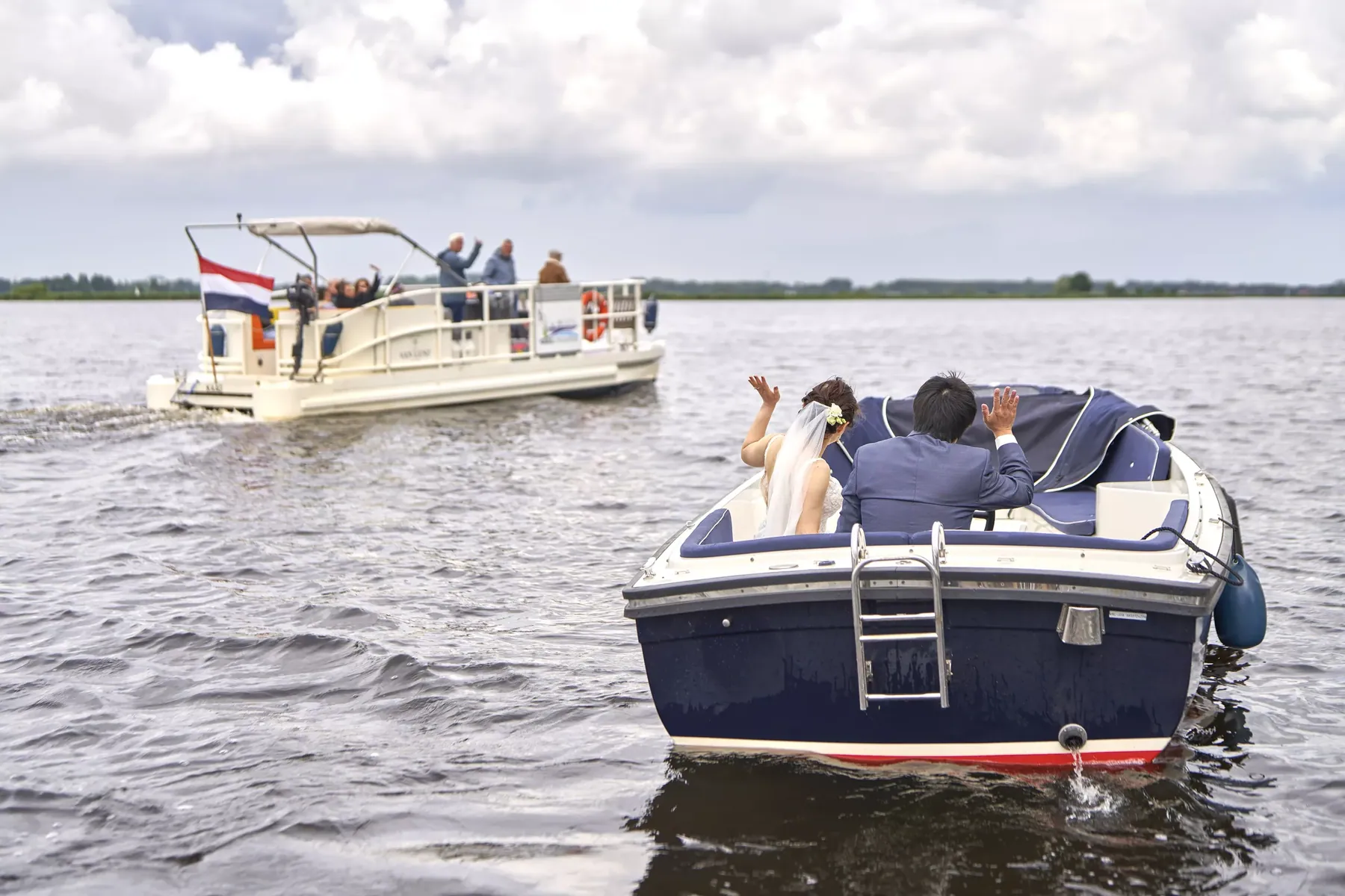 Bruidspaar vaart in een sloep over het water bij Almere